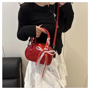 Rote Lackleder-Bowlingtasche mit weißer Spitzenschleife am Modell getragen