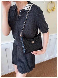 Detail shot of the black quilted chain bag featuring a gold buckle and leather strap