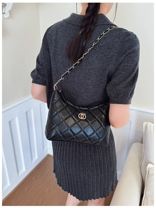 Détail du sac bandoulière noir matelassé avec chaîne dorée et anneaux métalliques croisés