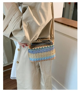 Dettaglio borsa in paglia intrecciata con motivo etnico colorato e chiusura in metallo