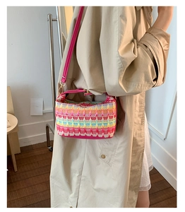 Dettaglio borsa tote tessuta colorata con tracolla in pelle rosa e fibbia dorata