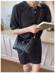 Détail du sac matelassé noir avec boucle dorée à double anneau et bandoulière chaîne