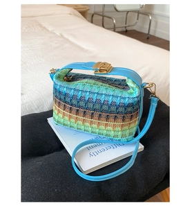 Dettaglio della trama colorata a onde con tracolla in pelle blu e fibbia d'oro della borsa