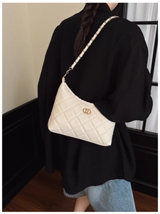 Detail of white quilted faux leather bag with gold chain strap and metal buckle