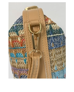 Detail of colorful woven fiber texture with gold-tone metal hardware and leather trim