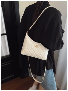 Close-up of quilted white crossbody bag with golden dual-ring buckle and thick chain detail