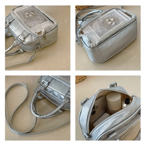 Detail of silver metallic tote bag featuring a clear card slot and multi-layer zippers
