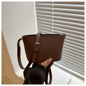 Detail of brown faux leather shoulder bag with FANYISSA embossing and silver buckles