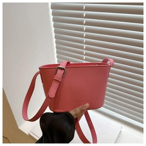 Detail view of pink mini bucket bag with FANYISSA embossed logo and adjustable strap