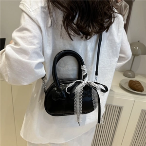 Chic black patent leather crossbody bag with lace ribbon and bow relief detailing