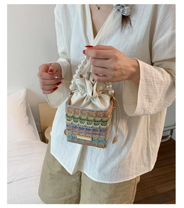 Detail of woven bucket bag featuring pearl handle and colorful geometric patterns