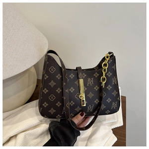 Detailed view of dark brown vintage patterned handbag with gold clasp and chunky chain link