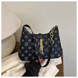 Detail of black geometric monogram handbag with gold chain and elegant metal clasp