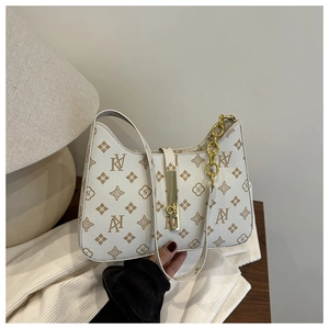 Detail of vintage floral print underarm bag with gold chain and metal lock closure