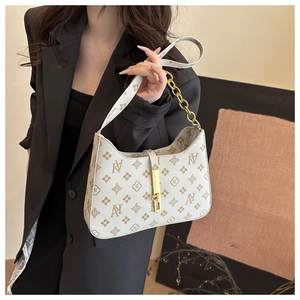 Detail of vintage floral print beige underarm bag with gold chain and metal clasp