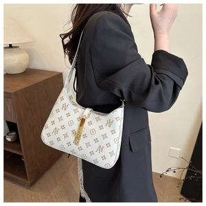 Chic monogram hobo bag in cream and coffee tones worn by a model in a warm interior