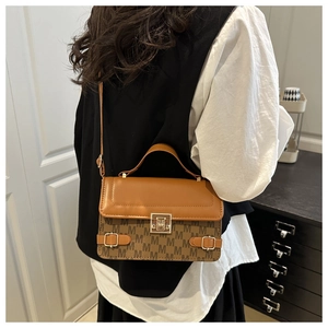 Close-up of retro square handbag with M-pattern print and metallic square lock detail