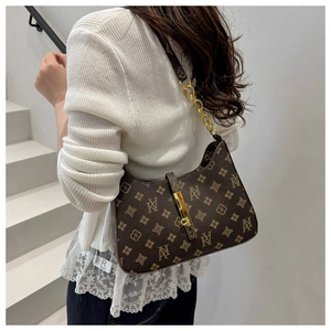 Detail of vintage monogram shoulder bag with gold chain and metal buckle on white knitwear