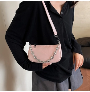 Vista dettagliata della borsa sottobraccio in pelle rosa con catena d'argento decorativa