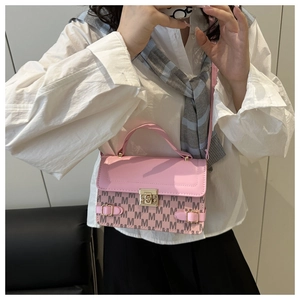 Detailed shot of pink crossbody bag with monogram pattern and gold buckle