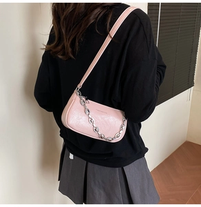 Dettaglio borsa a spalla rosa chiaro in pelle cerata lucida con catena decorativa