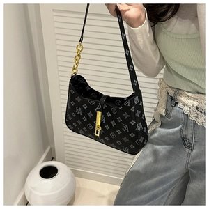 Detail of black monogram shoulder bag with gold chain strap and metallic buckle