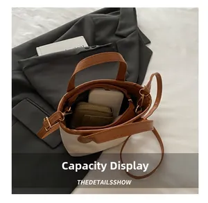 Mini sac seau en toile montrant l'espace pour un smartphone et un portefeuille en cuir