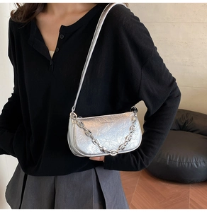 Dettaglio borsa in pelle stropicciata argento con tracolla sottile e catena metallica