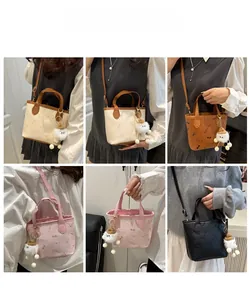 Détail du mini sac seau avec imprimé SMNL et breloque en peluche en plusieurs coloris
