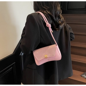 Détail du sac rose à paillettes avec fermoir doré carré et bandoulière en cuir noué