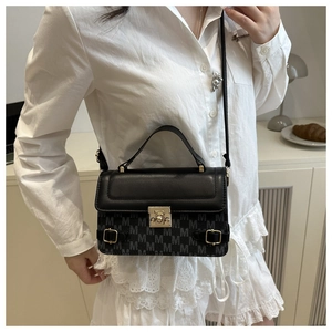 Fashionable black crossbody bag with M letter pattern and gold hardware on model