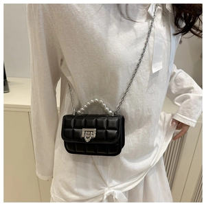 Detail of black quilted crossbody bag with pearl handle and silver chain strap