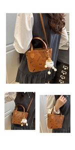 Détail du mini sac seau en cuir caramel avec imprimé chien cartoon et breloque peluche