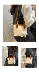 Détail d'un mini sac seau en cuir crème avec motifs embossés et breloque peluche