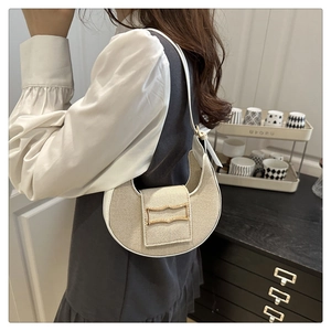 Détail du sac demi-lune tissé beige avec bordure blanche et boucle en métal doré