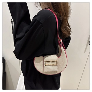 Vue latérale d'un sac demi-lune en toile avec bordure en cuir magenta et boucle dorée