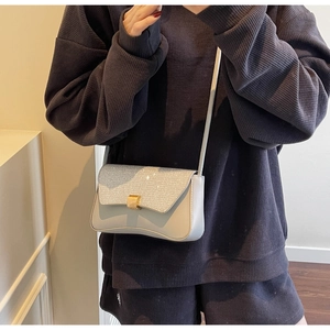 Détail du sac à bandoulière bleu clair avec rabat pailleté argenté et fermoir doré chic