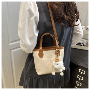 Mini sac seau crème chic avec motifs embossés et breloque en peluche en bandoulière