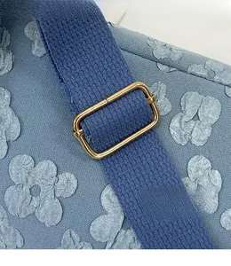 Detail of light blue canvas bag featuring 3D floral jacquard and golden metal buckle