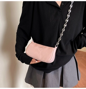 Borsa a spalla in pelle verniciata stropicciata rosa con catena argento indossata