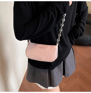 Dettaglio borsa baguette rosa con catena metallica argentata e finitura in ecopelle