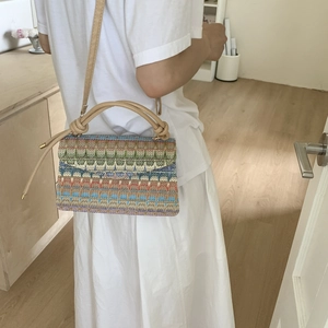 Minimalist knit crossbody bag with colorful wavy pattern and stylish round handles