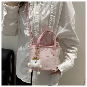 Mini sac seau rose avec imprimés dessins animés et un charmant pompon en peluche