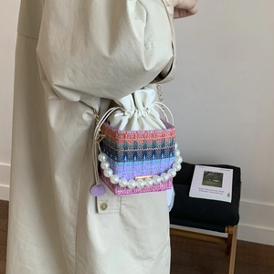 Colorful woven mini square bag with pearl handle and chain strap on a model