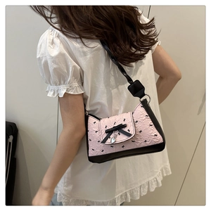 Detail of pink ruffled texture fabric with black bow patterns and silver heart pendant