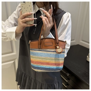 Détail du sac à bandoulière tissé coloré avec poignées en cuir et pendentif doré