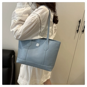 Light blue faux leather tote bag with embossed laurel patterns and top handle