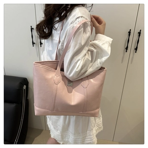 Detail of pink embossed tote bag showing textured leather surface and stylish shoulder strap