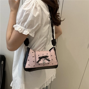 Pink bow underarm bag with pleated fabric and silver heart charm on black woven strap