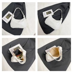 Detail of white woven textured hobo bag showing spacious interior and sleek profile